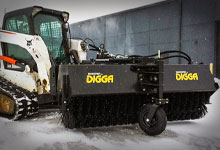 Tracked loader with a Digga Sweeper Broom in the snow.